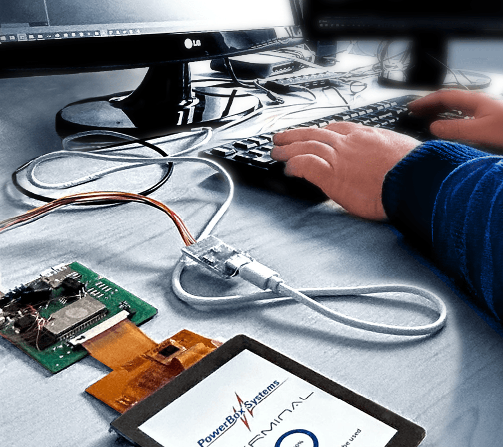 Softwareentwickler arbeitet am PC mit elektronischen Bauteilen.